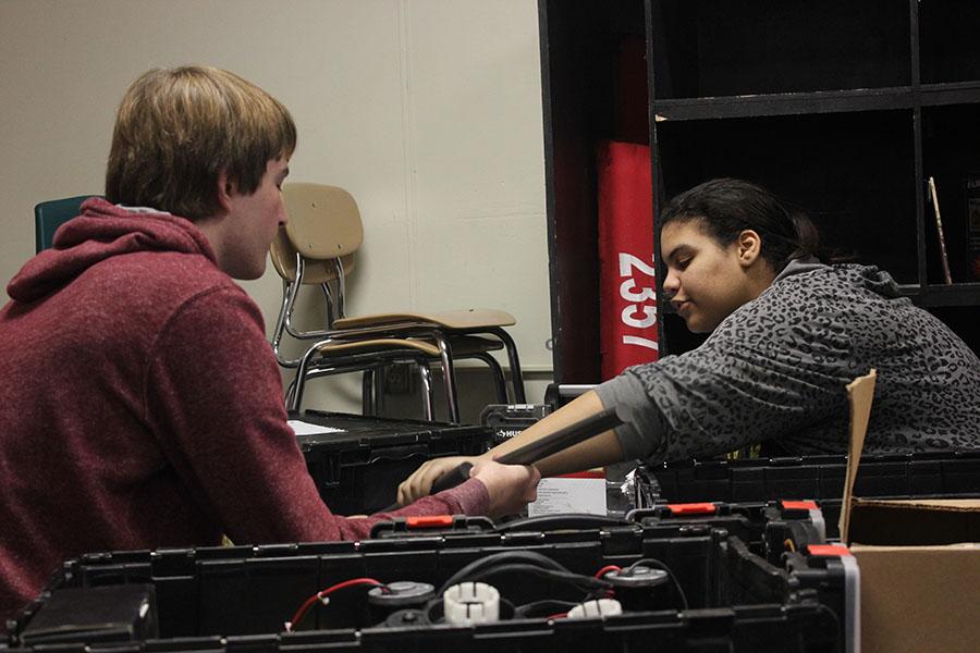Working on separating some of the parts in the moving boxes, Juniors Andrea Shaw and Jason Lewis are doing their part to help the move to the Academy Building Room 310.
