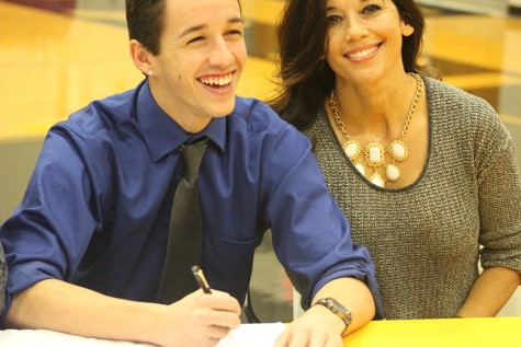 Signing with Graceland to play soccer, Anthony Hedges laughs at a congratulatory joke made by one of his family members.