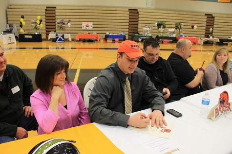 Jason Bell signs with Baker University to play football.
