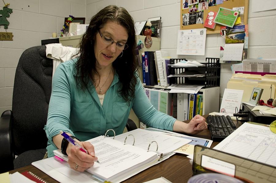 IB+instructor+Lisa+Roberts+studies+the+new+curriculum+for+her+students.