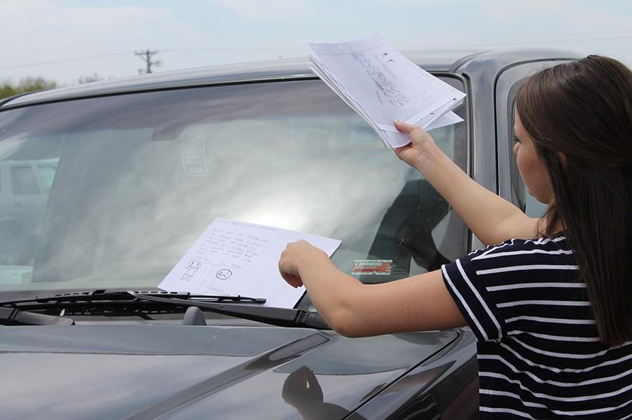 SADD members place notes from elementary school on cars before prom