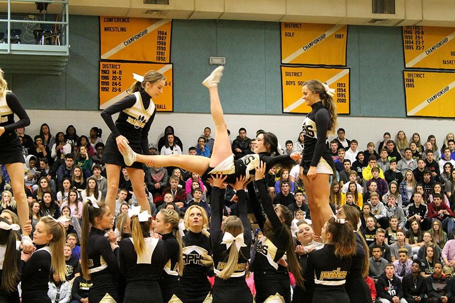 Flipping between positions, cheerleaders perform during the pep rally. 