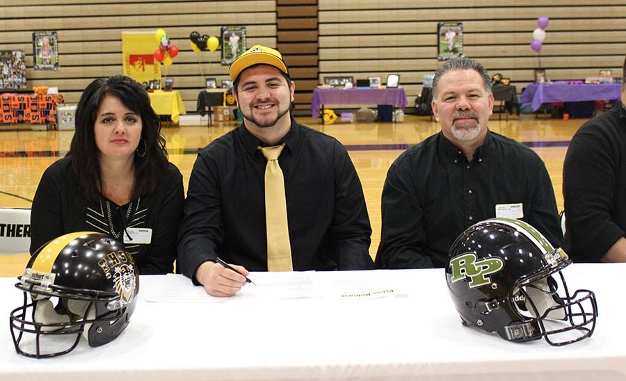 John Lucero is joined by his parents as he signs to continue his football career at Fort Hayes University.