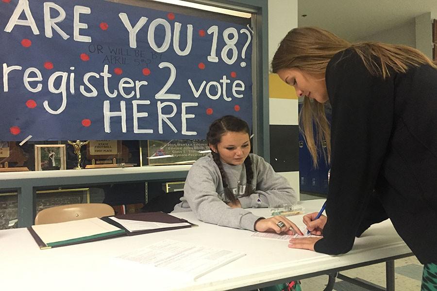 Quick+and+easy.+Registering+to+vote+in+the+upcoming+election%2C+senior+Josie+Hilsabeck+fills+out+her+registration+card+with+assistance+from+senior+Alyson+Van+Winkle.+Students+are+encouraged+to+register+to+vote+for+the+elections+to+take+place+within+the+next+couple+of+months+with+a+table+run+by+Student+Senate+set+up+during+lunch.+photo+by+maddie+reihs