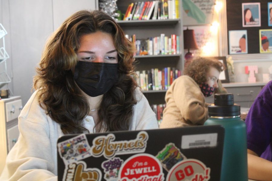 WORK. Wearing a mask, junior Gabriela Vides goes over her classwork. Masks are required for all students to wear while in the school.